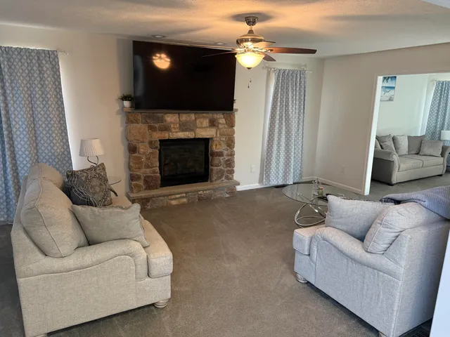 a living room with furniture a flat screen tv and a fireplace