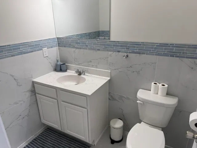 a bathroom with a toilet sink and mirror