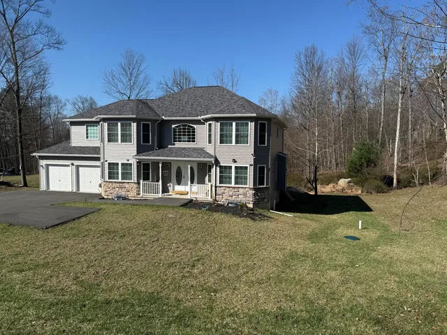 a front view of a house with a garden and yard