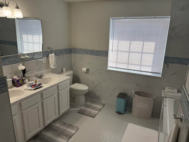 a bathroom with a toilet sink and mirror