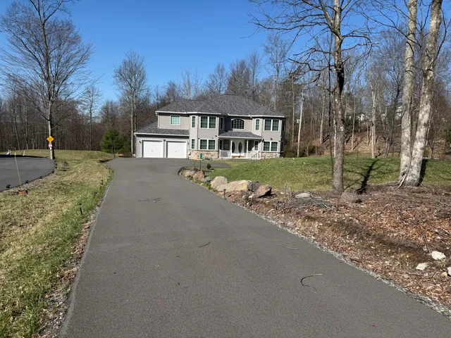 a front view of a house with a yard and trees