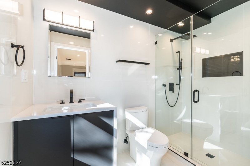 76 Burnet Road, Unit 2 Florham Park, NJ 07940 - Photo 13 of 24 a bathroom with a sink toilet mirror and shower