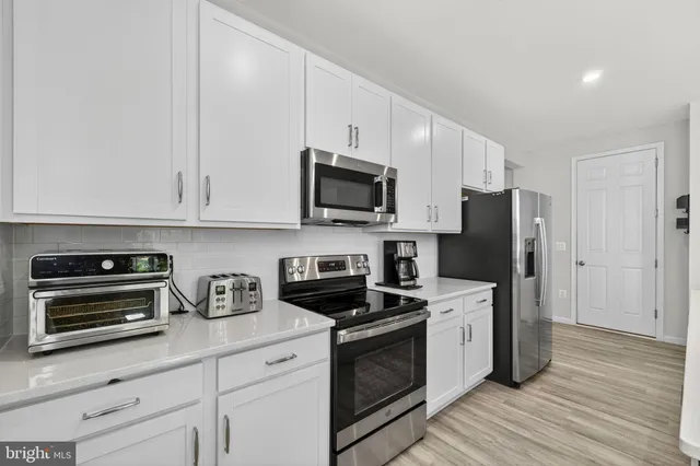 a living room with furniture and a view of kitchen
