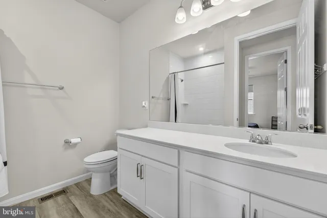 a view of kitchen with stainless steel appliances granite countertop a stove and a wooden floors