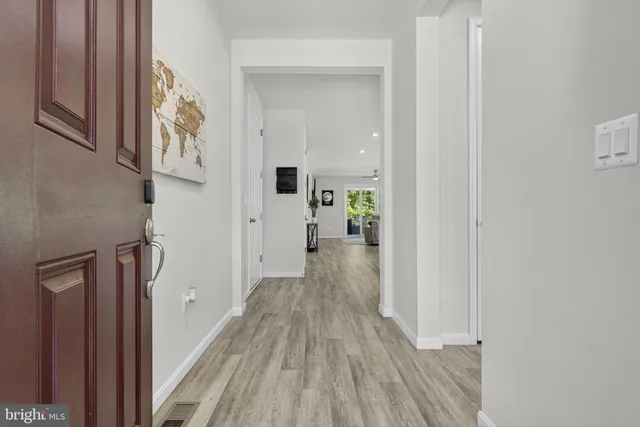 a view of a hallway with wooden floor and staircase