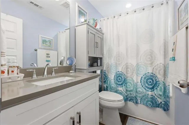 a bathroom with a granite countertop toilet sink and mirror