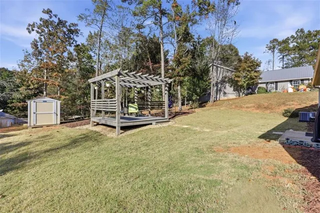 a view of a house with a yard and large trees