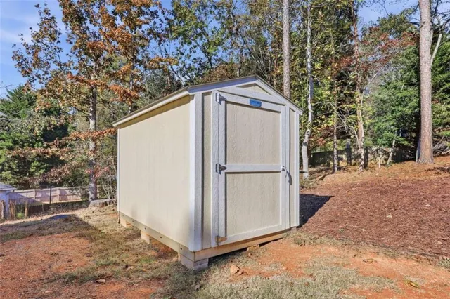 a white house covered with tall trees