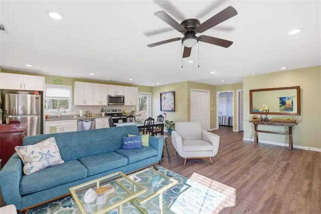 a living room with furniture and view of kitchen