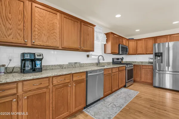 a kitchen with granite countertop a sink stainless steel appliances and cabinets