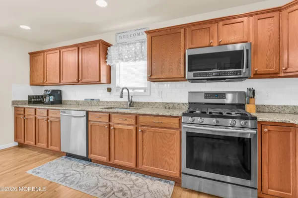 a kitchen with stainless steel appliances granite countertop a stove a sink and a microwave