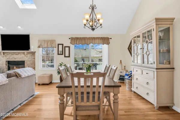 a view of a dining room with furniture a chandelier and wooden floor