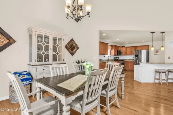 a view of a dining room with furniture a chandelier and wooden floor