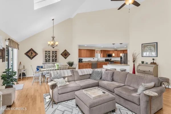 a living room with furniture kitchen view and a chandelier
