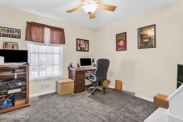 a view of a livingroom with workspace and a window