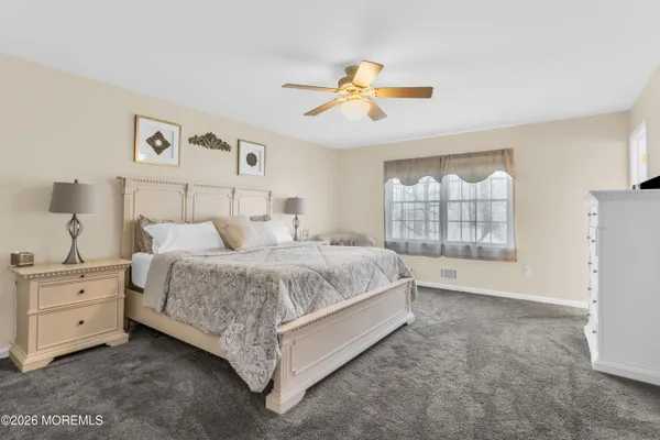 a spacious bedroom with a bed and a window
