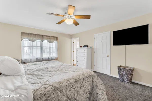 a spacious bedroom with a bed and a flat screen tv