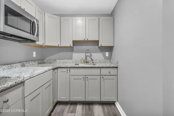 a kitchen with granite countertop white cabinets and stainless steel appliances