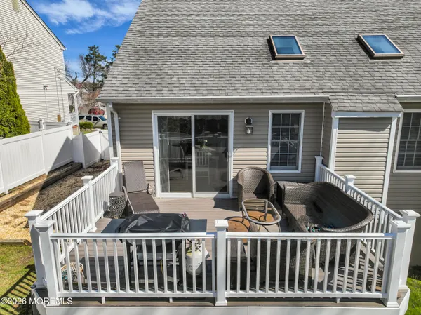 a view of house with deck and furniture