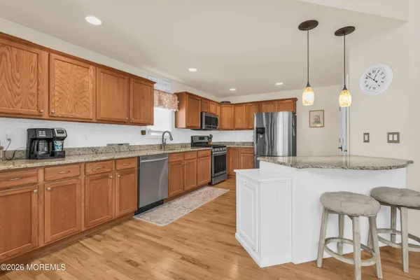 a large kitchen with kitchen island a island a stove a sink a counter space and dining table