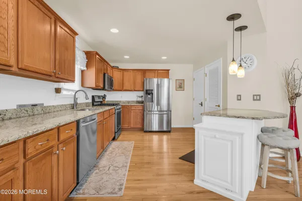 a kitchen with stainless steel appliances granite countertop a sink and a refrigerator