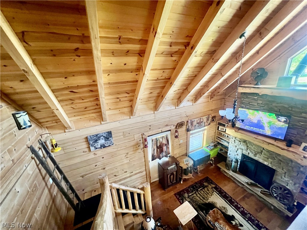39589 National Road Bethesda, OH 43719 - Photo 15 of 35 Unfurnished living room featuring beam ceiling, wooden ceiling, wooden walls, and hardwood / wood-style floors