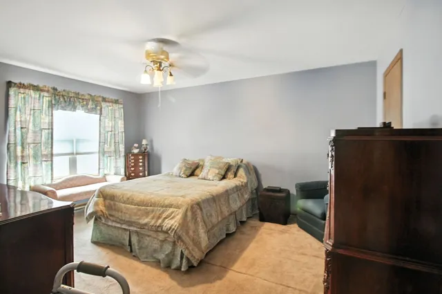 a bedroom with a bed dresser and a window