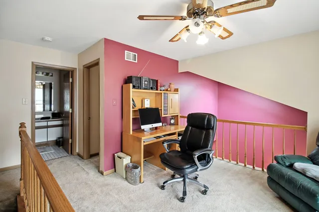 a view of a workspace with furniture and a window