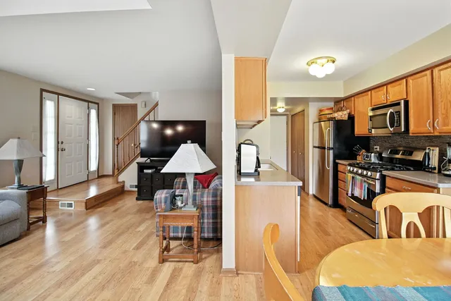 a living room with furniture a flat screen tv and kitchen view
