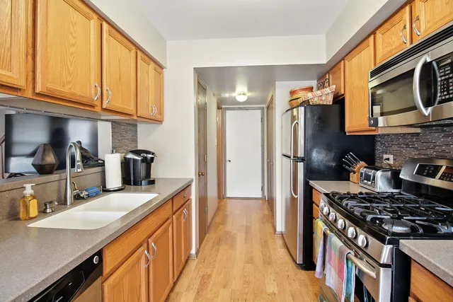 a kitchen with stainless steel appliances granite countertop a stove a sink dishwasher and a refrigerator