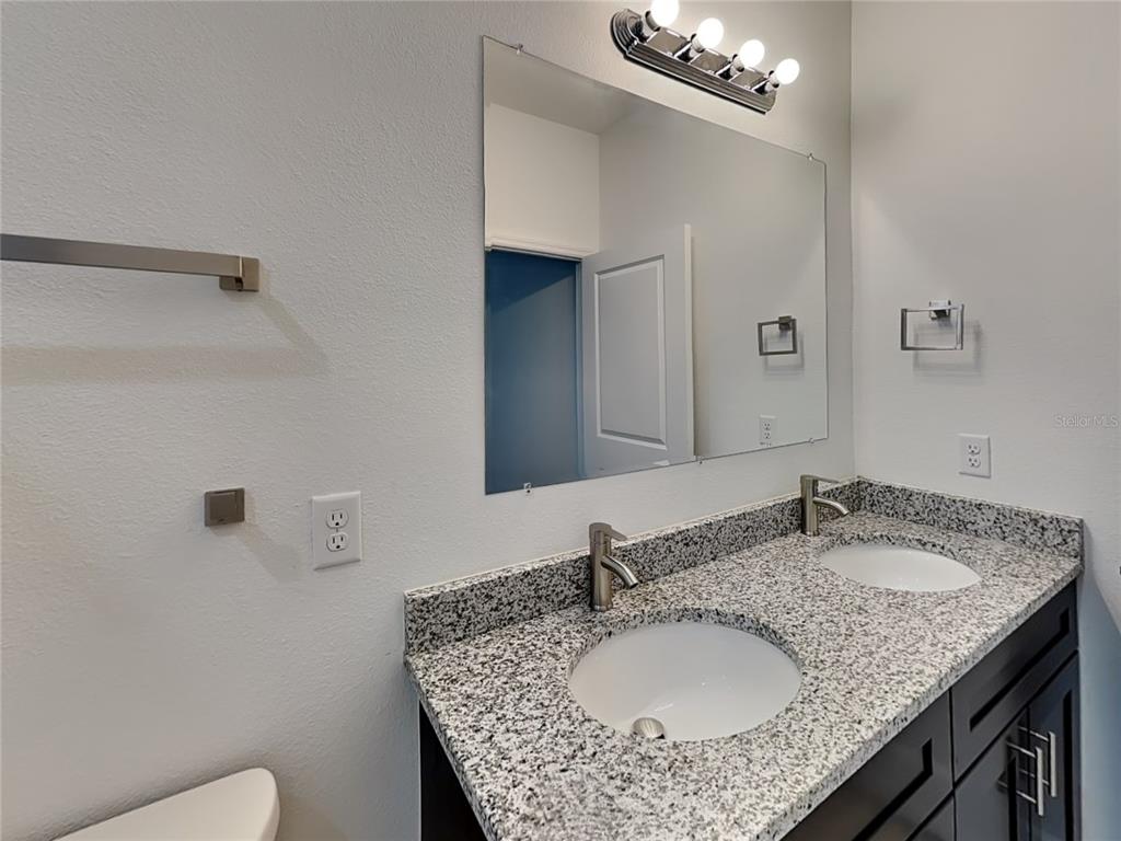 8809 North Sandree Drive Citrus Springs, FL 34434 - Photo 7 of 16 a bathroom with a granite countertop sink a toilet and a mirror