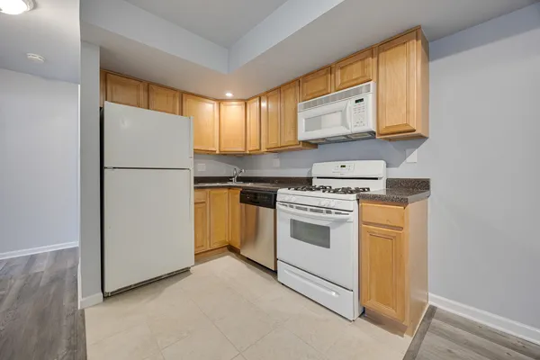 a kitchen with white cabinets and white appliances