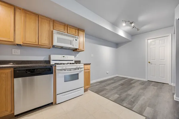 a kitchen with granite countertop cabinets stainless steel appliances and wooden floor