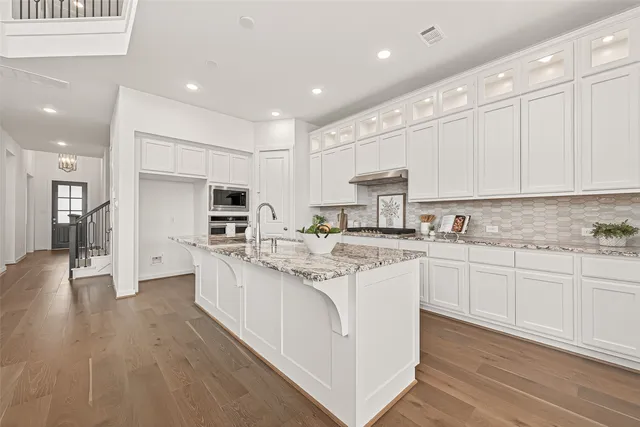 a kitchen with stainless steel appliances granite countertop a sink and cabinets