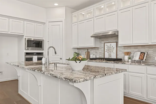 a kitchen with stainless steel appliances granite countertop a sink a stove and cabinets