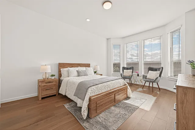 a bedroom with a bed a table and a large window