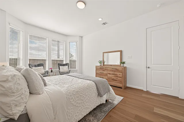 a bedroom with a bed and wooden floor