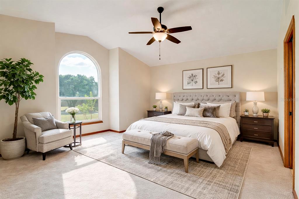 1504 East Spring Ridge Circle Winter Garden, FL 34787 - Photo 12 of 21 a spacious bedroom with a bed a couch and a large window