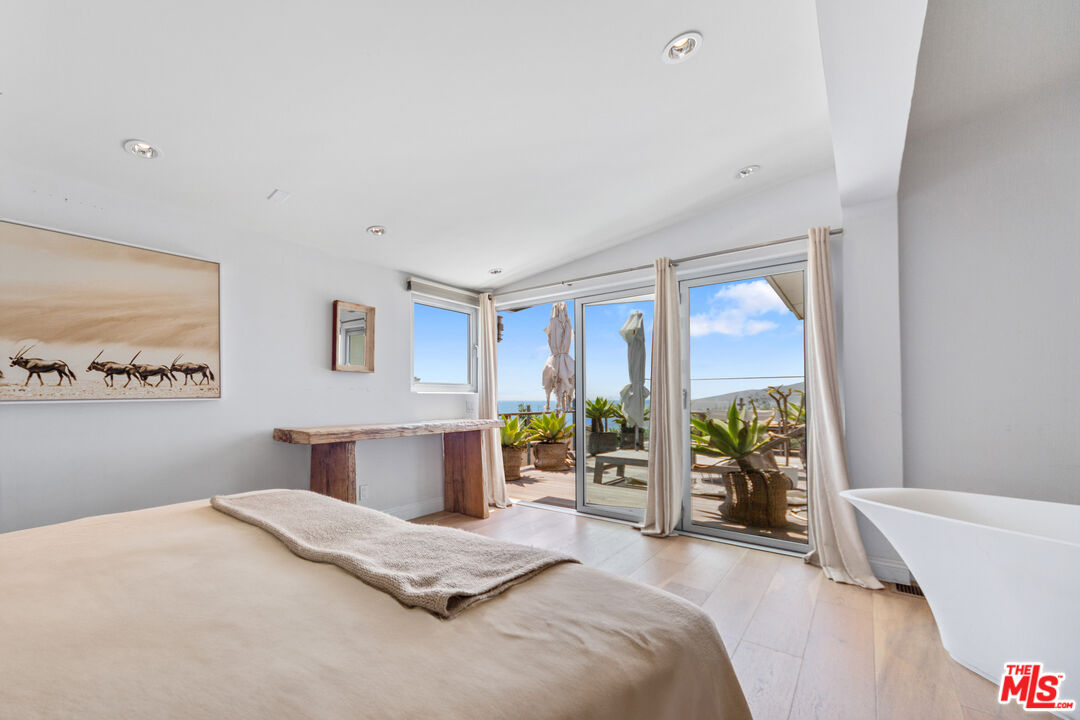 29500 Heathercliff Road, Unit 184 Malibu, CA 90265 - Photo 14 of 46 a bedroom with a large bed and a large window