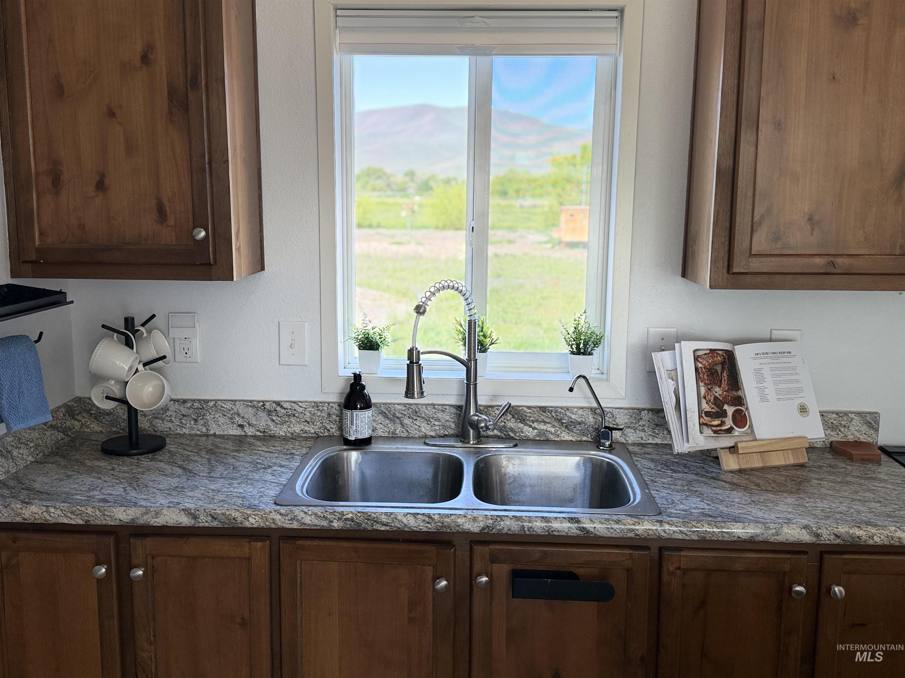 875 Eaton Road Weiser, ID 83672 - Photo 13 of 30 Kitchen featuring a double-basin stainless steel sink with a high-arch faucet, set into a speckled countertop