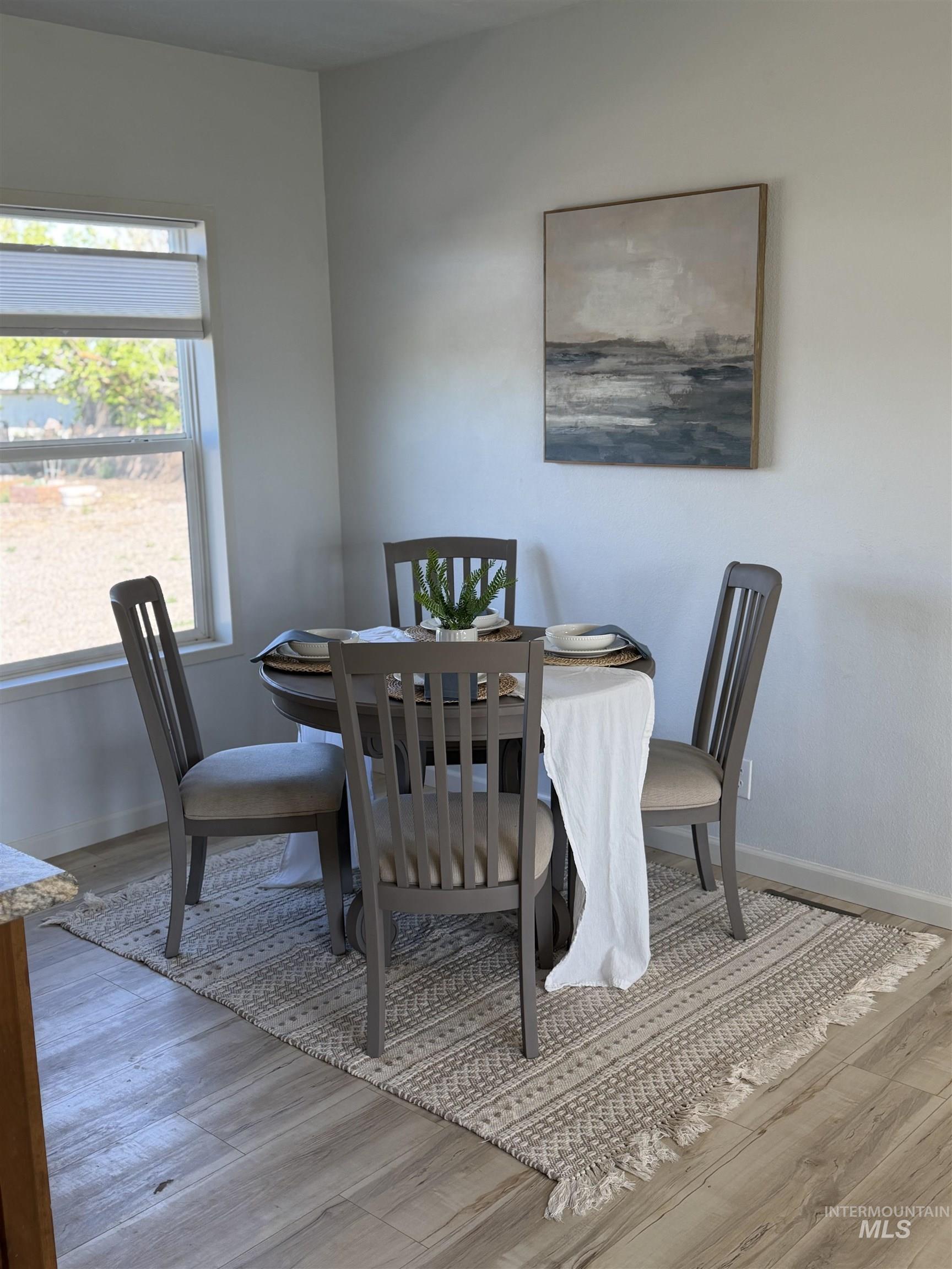 875 Eaton Road Weiser, ID 83672 - Photo 14 of 30 Bright dining area featuring wood-finish flooring, a window with horizontal blinds, and light-toned walls