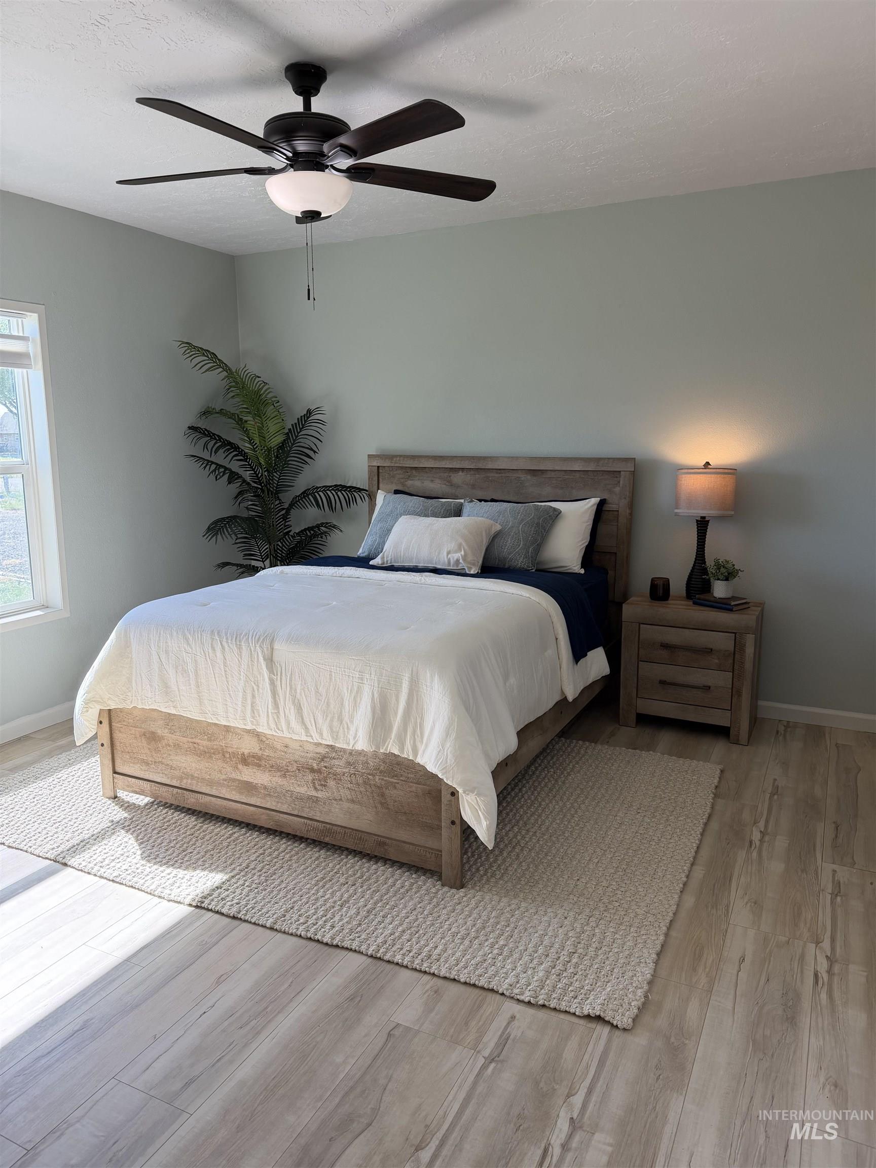 875 Eaton Road Weiser, ID 83672 - Photo 15 of 30 Spacious room featuring wood-finish flooring, a ceiling fan with integrated lighting, a window with natural light, and light-toned walls