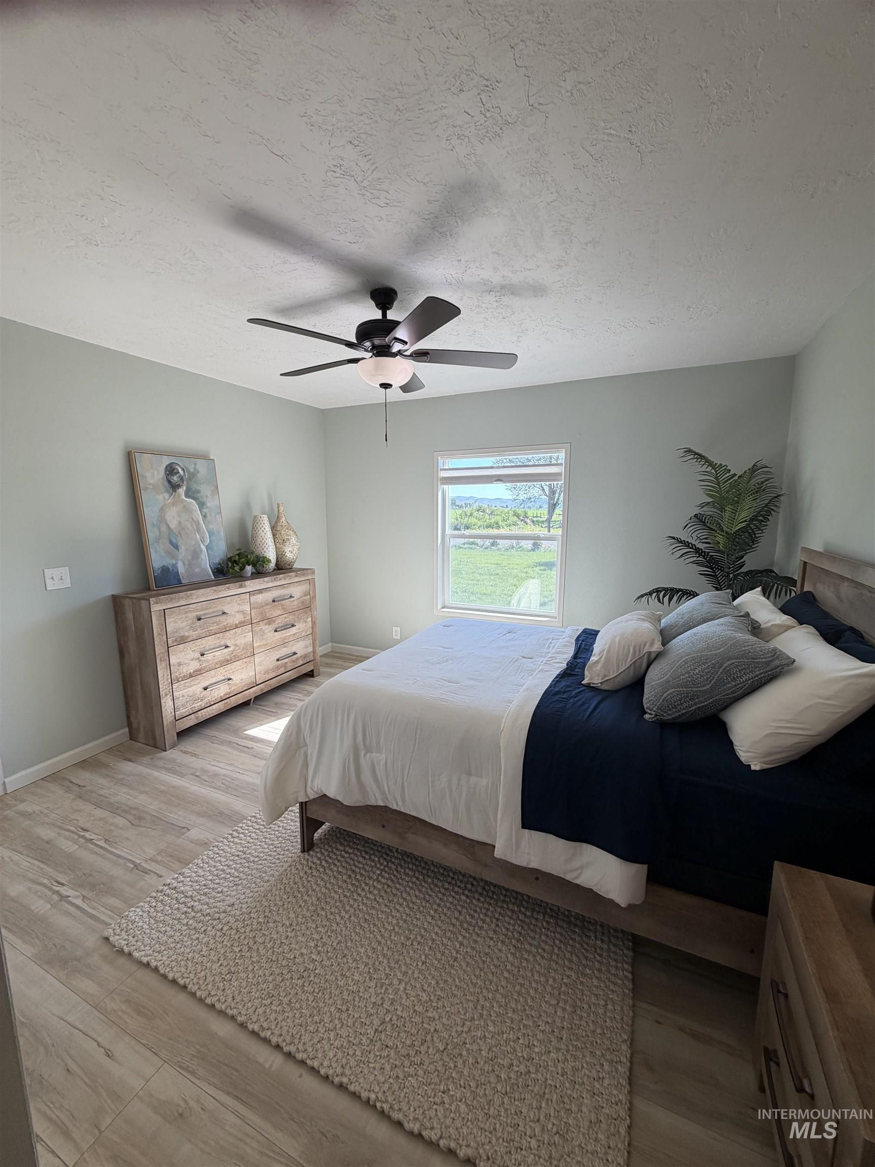 875 Eaton Road Weiser, ID 83672 - Photo 16 of 30 Spacious room featuring wood-finish flooring, light-toned walls, and a ceiling fan with integrated lighting