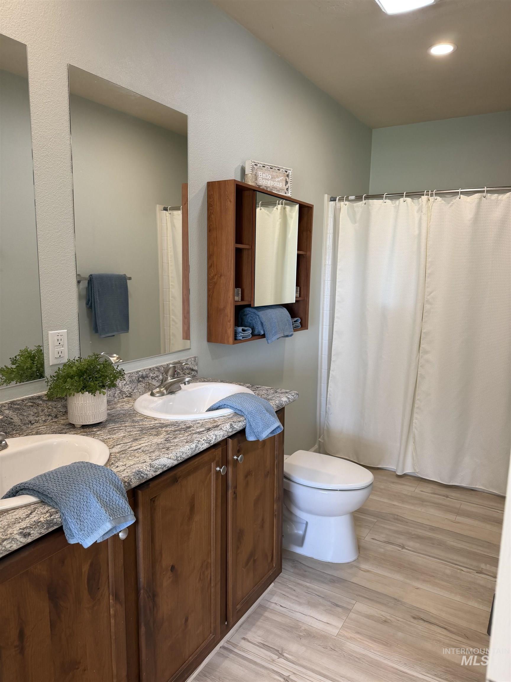 875 Eaton Road Weiser, ID 83672 - Photo 18 of 30 Bathroom featuring a dual vanity with a granite-look countertop, wood-finish cabinetry, and undermount sinks