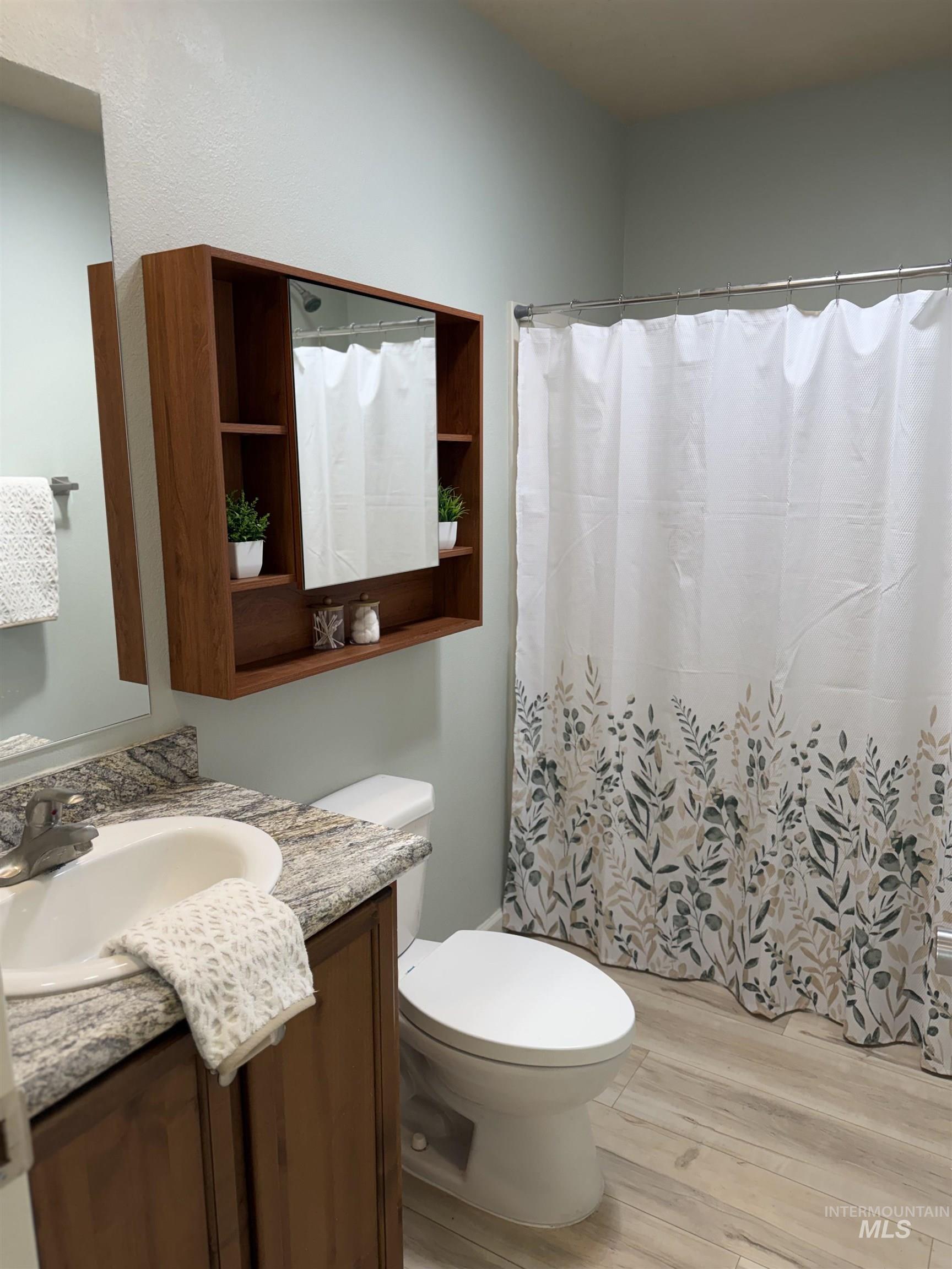 875 Eaton Road Weiser, ID 83672 - Photo 20 of 30 Bathroom with a single vanity, wood-finish cabinet, and granite-look countertop