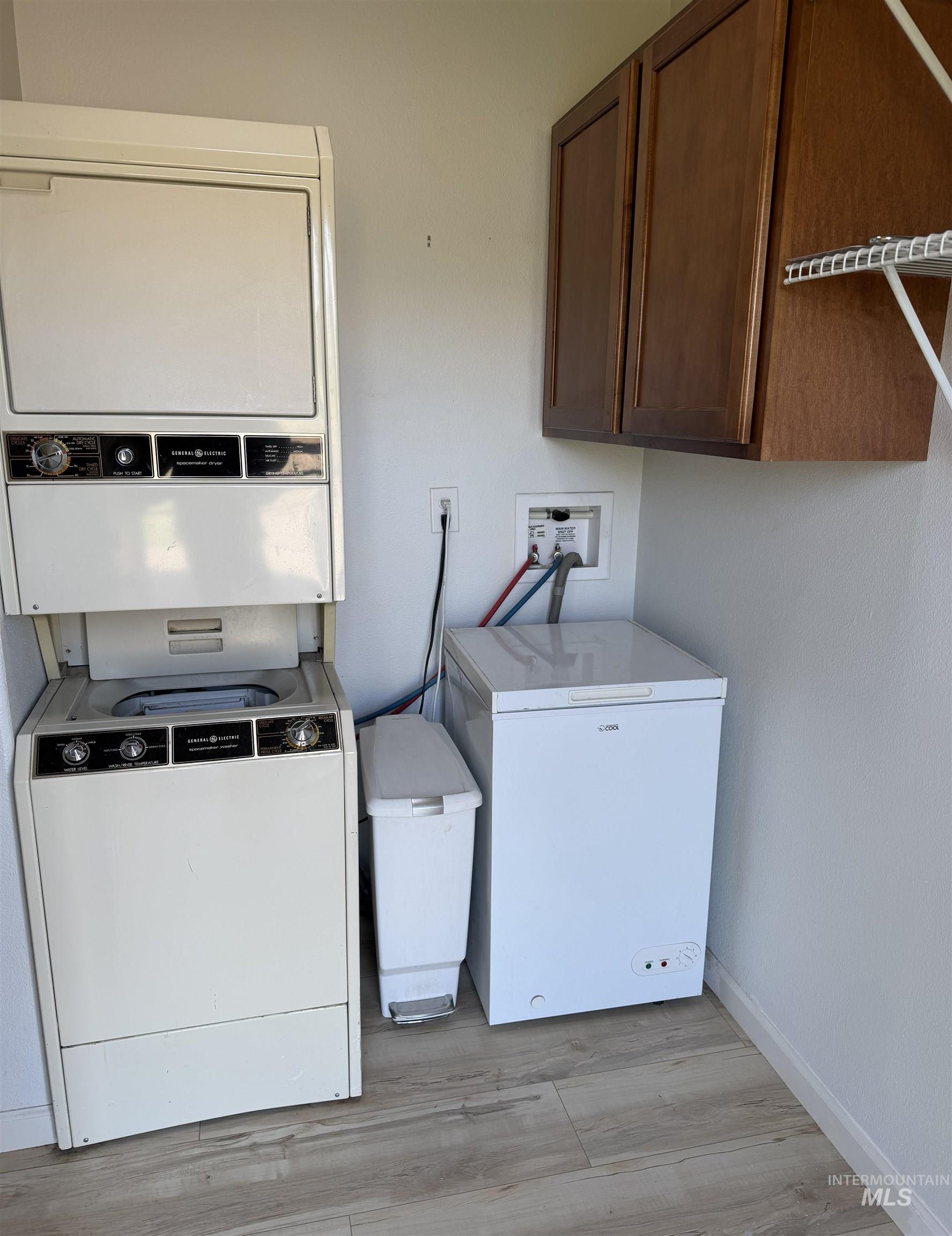 875 Eaton Road Weiser, ID 83672 - Photo 21 of 30 Laundry area featuring wood-finish flooring, wall-mounted cabinetry, and a utility hookup