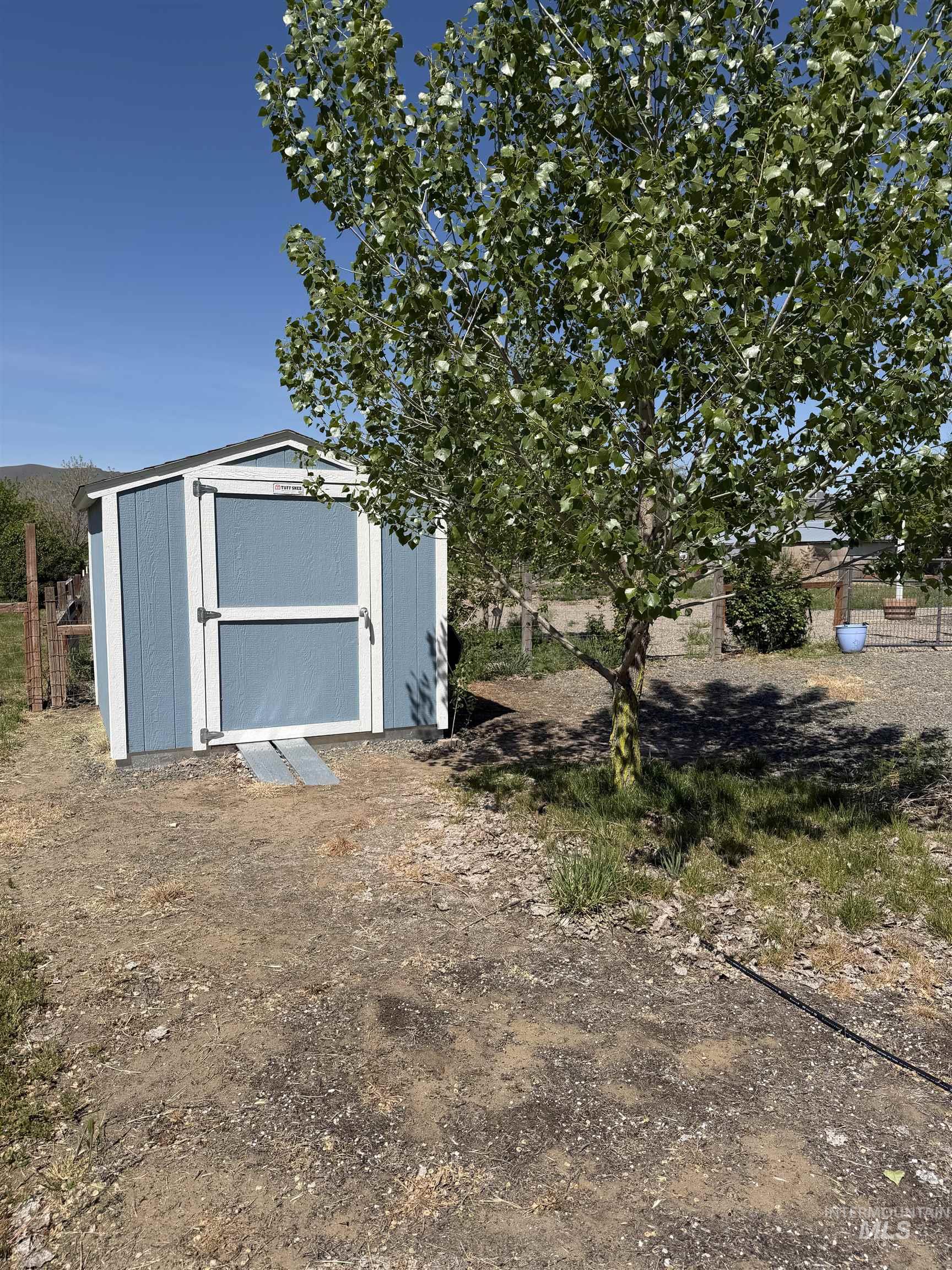 875 Eaton Road Weiser, ID 83672 - Photo 22 of 30 Freestanding storage shed with light blue siding, white trim, and a dark shingle roof