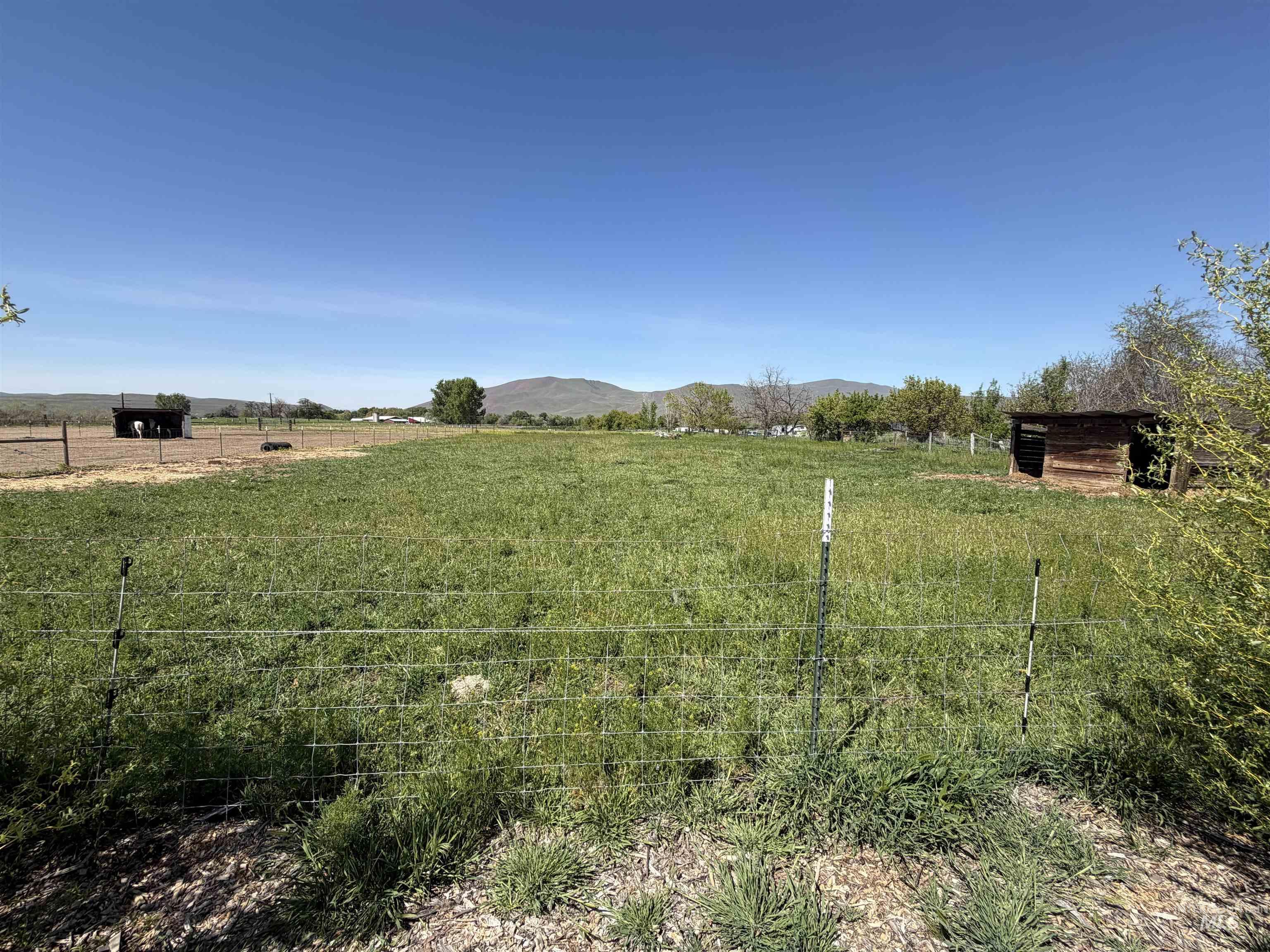 875 Eaton Road Weiser, ID 83672 - Photo 28 of 30 Expansive acreage featuring wire fencing, a wooden shelter, and a secondary structure