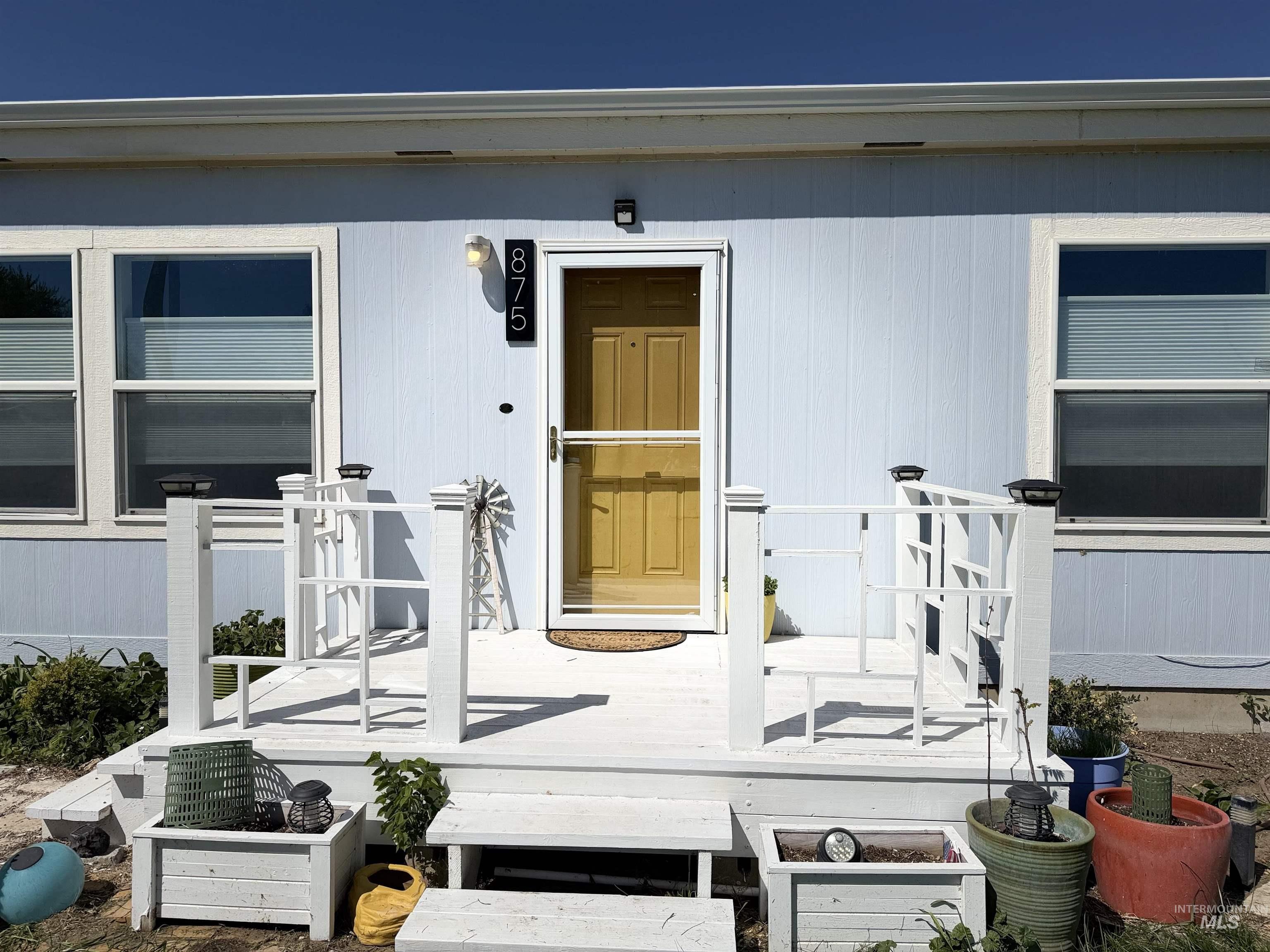 875 Eaton Road Weiser, ID 83672 - Photo 3 of 30 Light blue siding exterior featuring a white deck with railings and porch steps