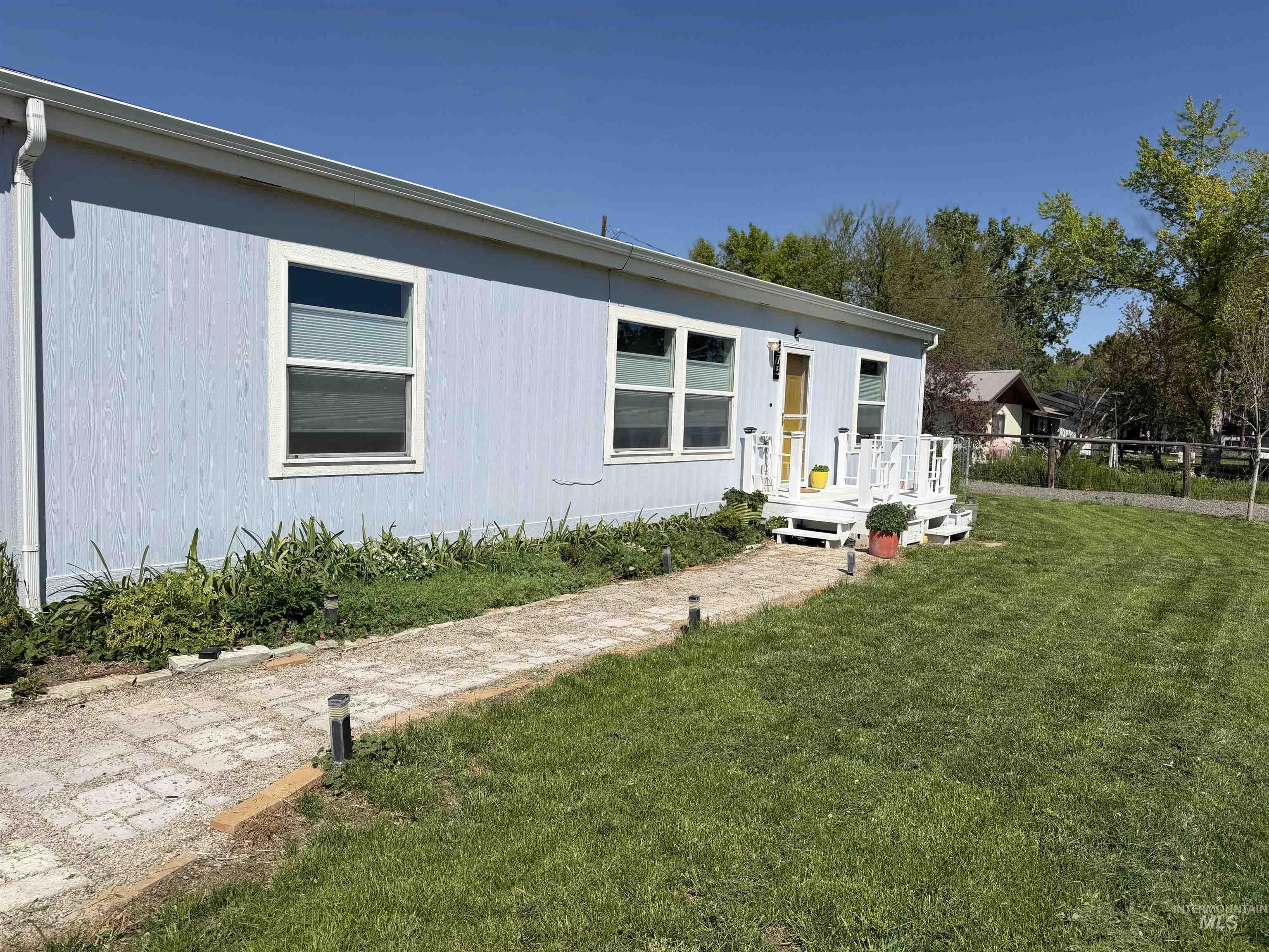 875 Eaton Road Weiser, ID 83672 - Photo 4 of 30 Light blue siding exterior featuring multiple windows and a white front porch